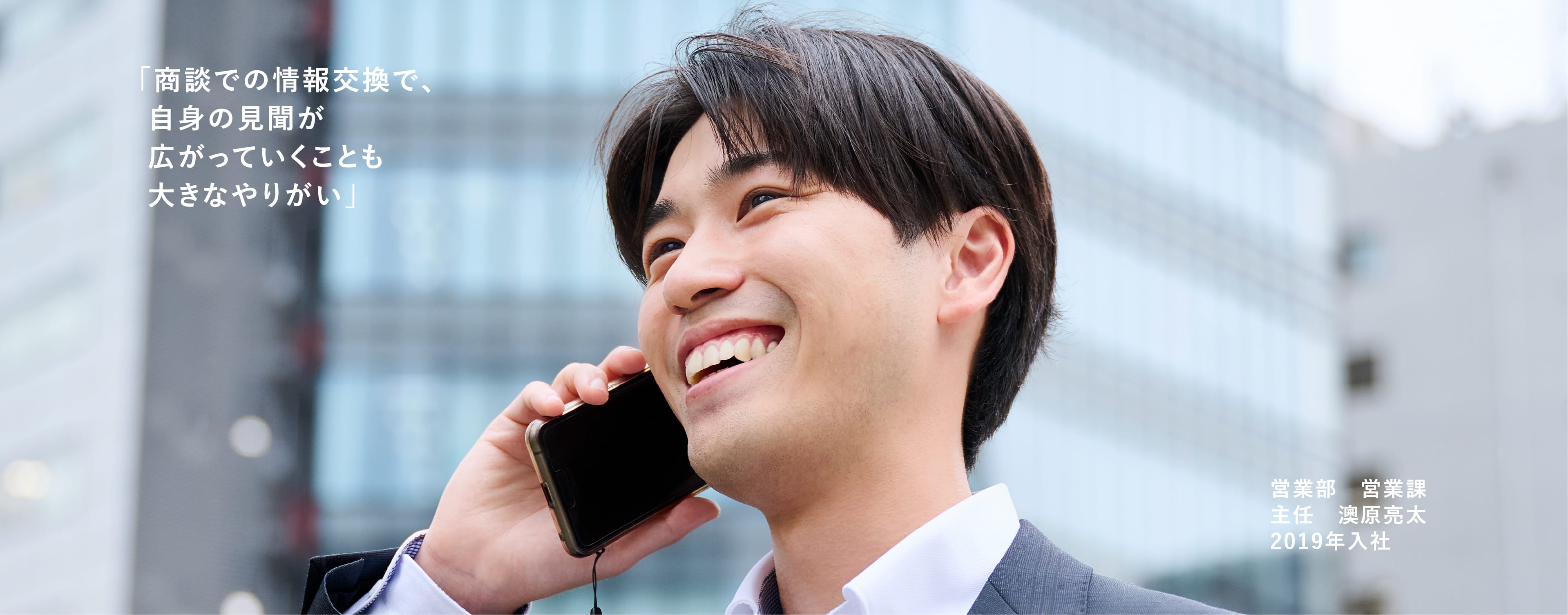 スマホで電話をしている笑顔の男性。営業部:営業課:主任 澳原 亮太 2019年入社